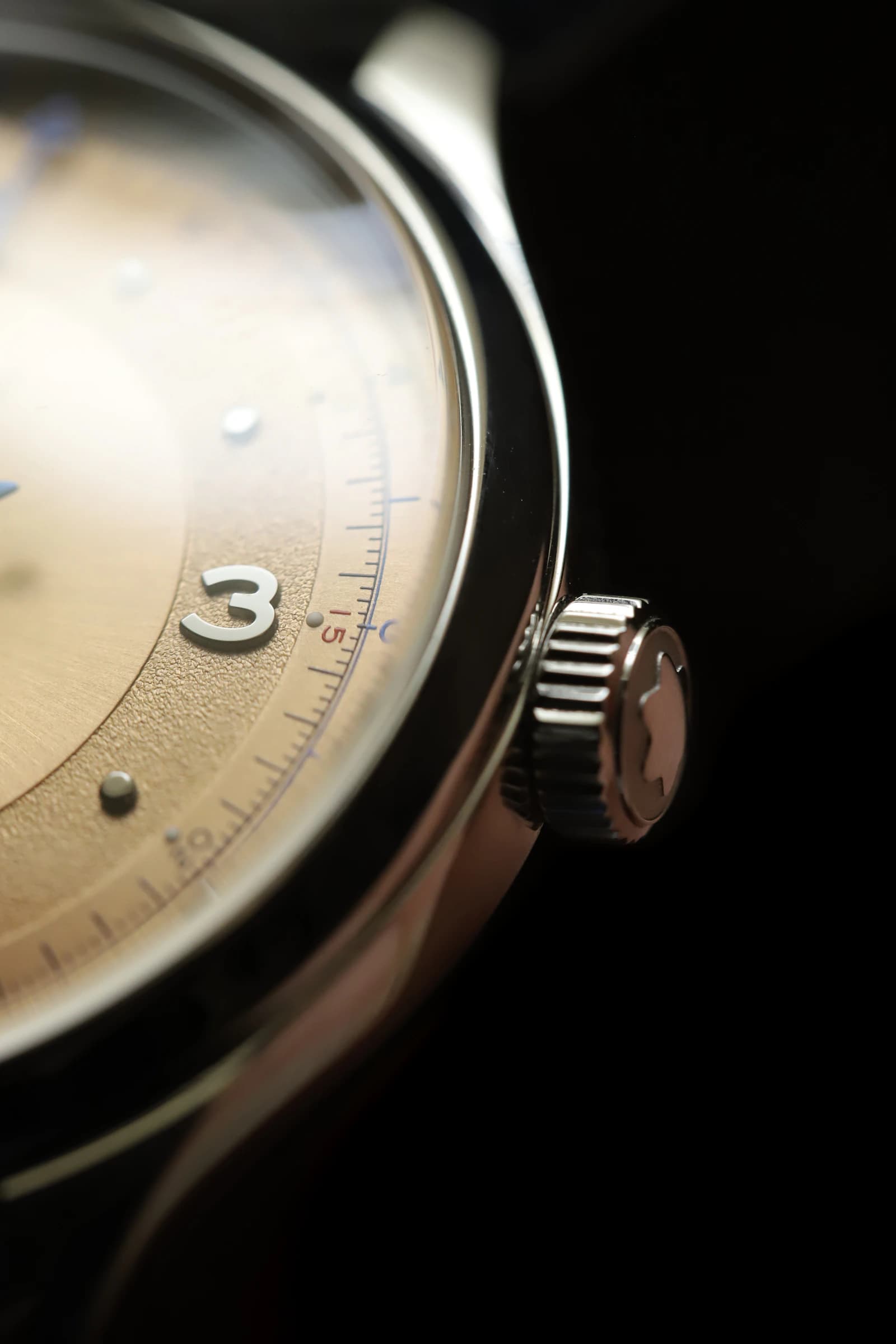 Macro photograph of a wristwatch on a black surface